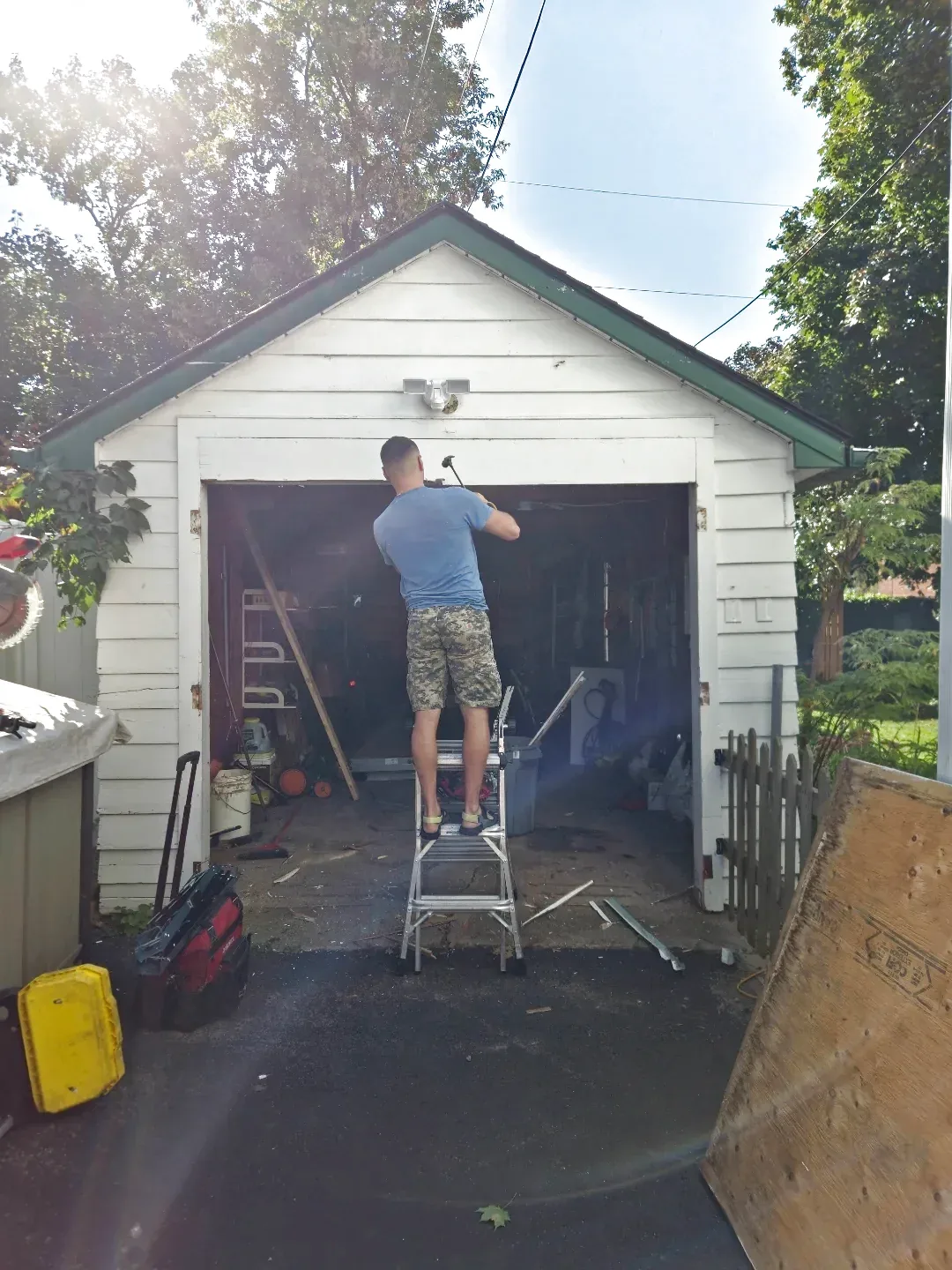Liftime owner Michael on a ladder installing aluminum capping around an Ottawa garage door frame